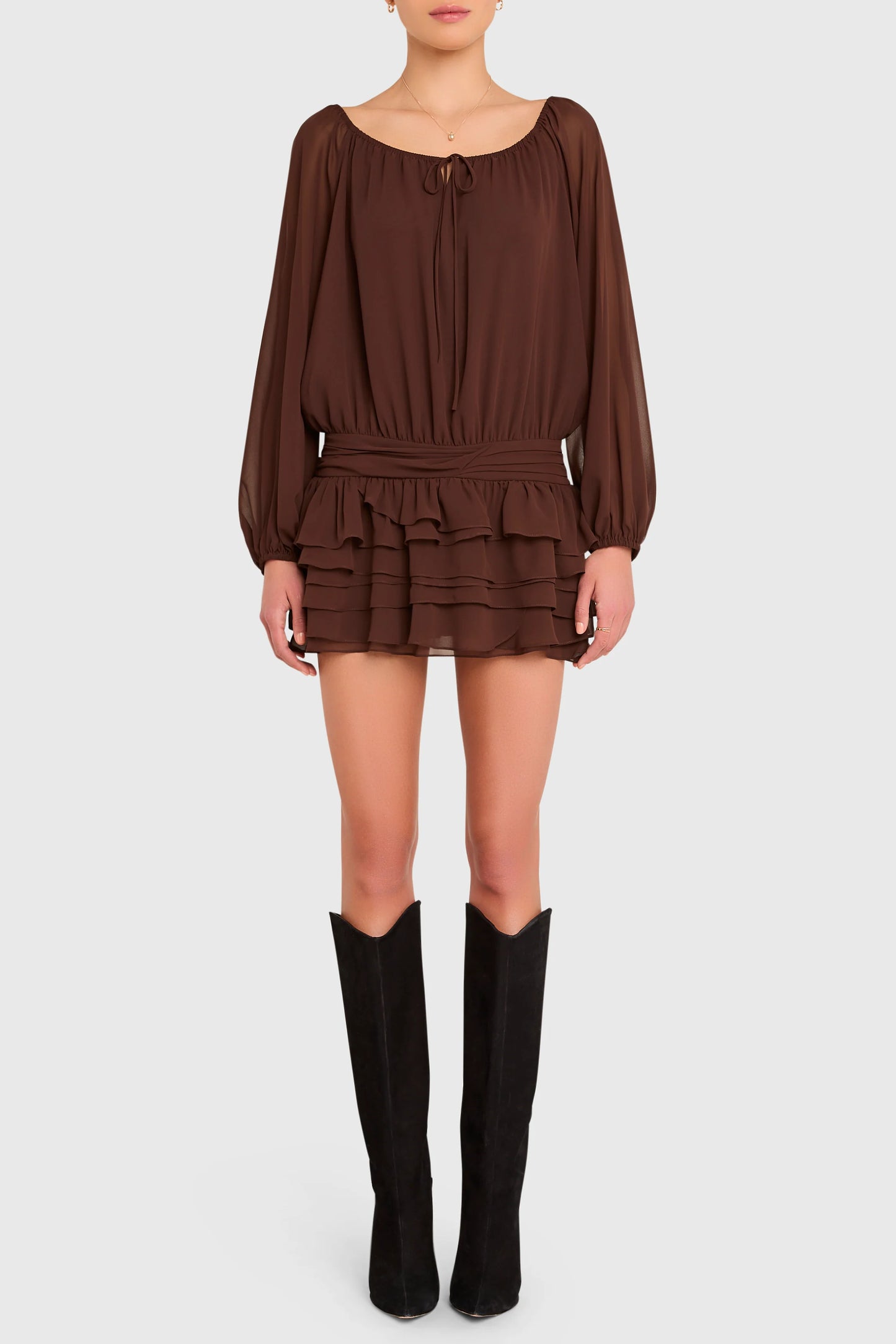 Brown dress with long sleeves and ruffled layers worn by a person on a white background. Dallas Romper Skort