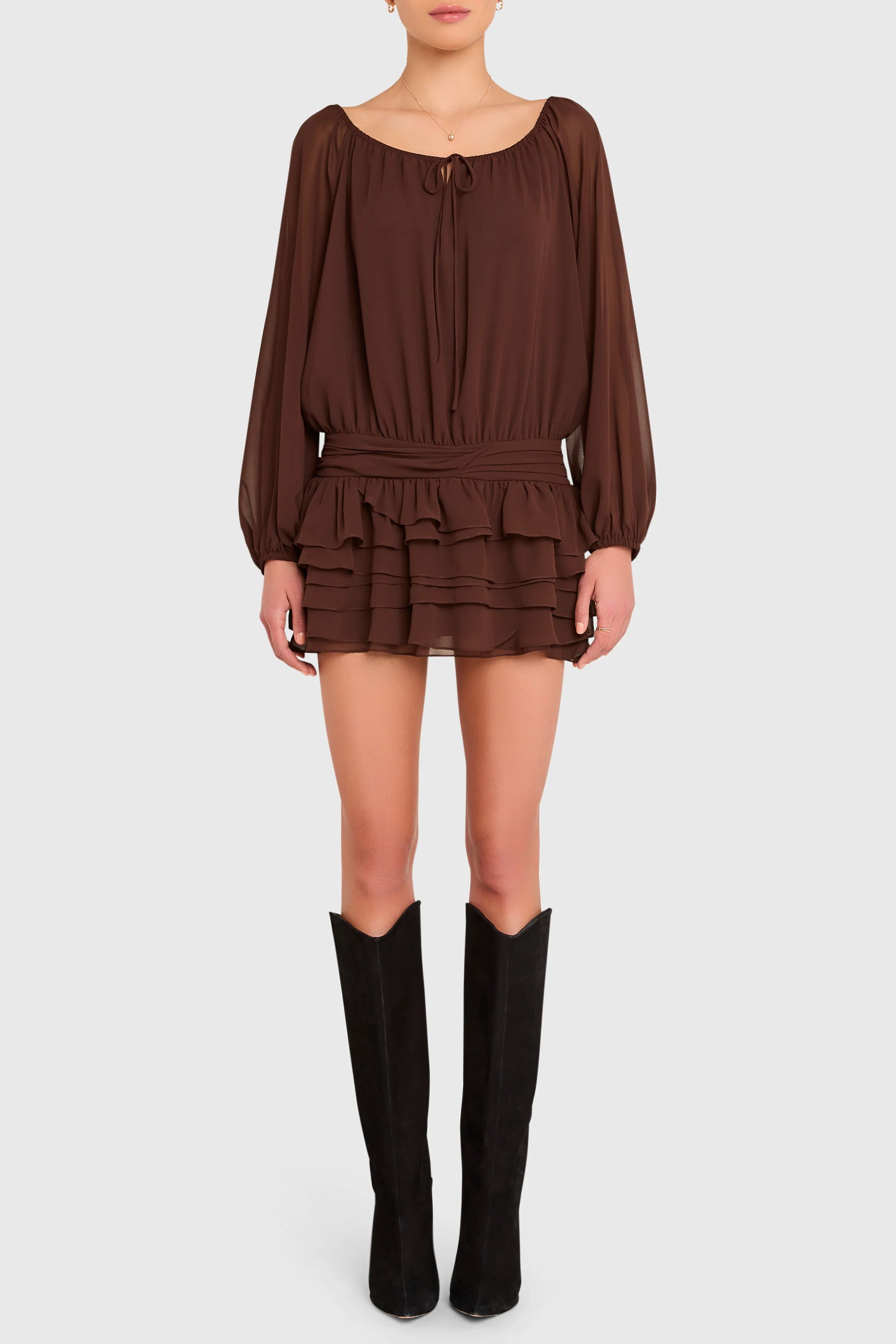 Brown dress with long sleeves and ruffled layers worn by a person on a white background. Dallas Romper Skort
